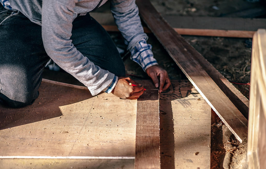 construction worker measuring drawing on wood studs