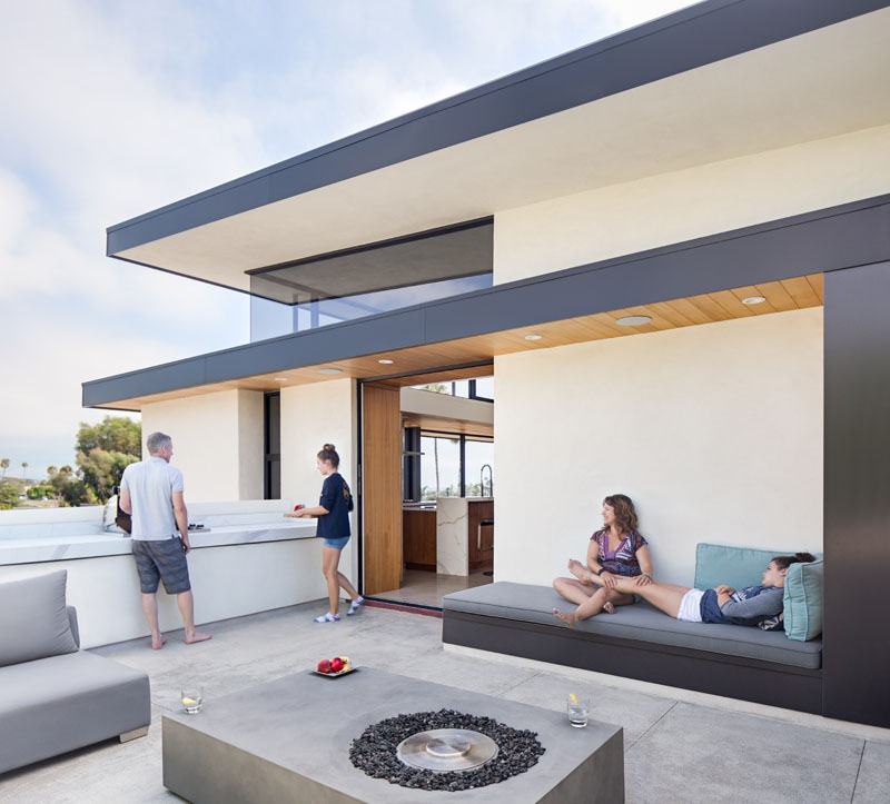 patio space with roof that becomes a bench next to fireplace