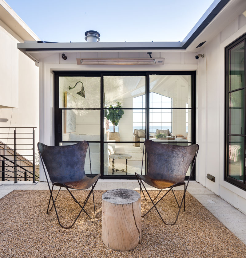 two chairs in patio space in front of segmented glass doors
